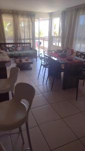 a living room with tables and chairs and a room with windows at Golden Dunas 123B in Extremóz +2 photos