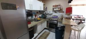 a kitchen with white cabinets and a refrigerator at Golden Dunas 123B in Extremóz