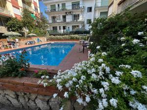 una piscina frente a un edificio con flores en home & pool 2, en Sorrento