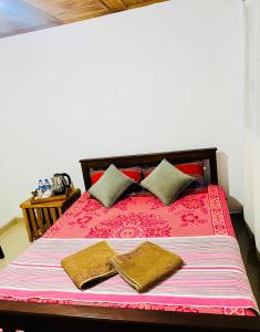 a bed with two pillows and two towels on it at DK Paddy Field Villa in Unawatuna in Unawatuna