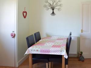 a dining room table with a quilt on it at Lavender Cottage in Buckfastleigh