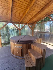 a pavilion with a table and benches on a deck at Békafütty Vendégház in Ráckeve +37 photos