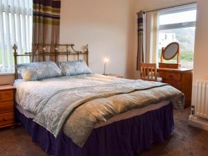 a bedroom with a bed with a mirror and a window at The Lobster Pot in Loftus