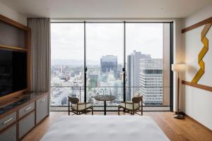 a bedroom with a view of a city at One Fukuoka Hotel in Fukuoka