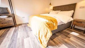Un dormitorio con una cama y suelo de madera. en Whitemills Wake and Aqua Park Lodge Four, en Richborough