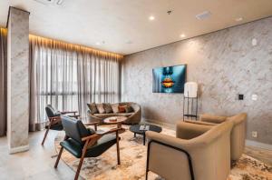 a living room with a couch and chairs and a table at Atmosfera 360 - Metrô Brooklin, Berrini e Consulado Americano in Água Boa