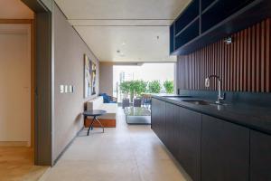 a kitchen with black cabinets and a sink at Atmosfera 360 - Metrô Brooklin, Berrini e Consulado Americano in Água Boa