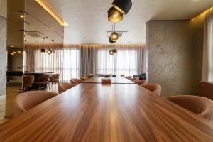 a conference room with a large wooden table and chairs at Atmosfera 360 - Metrô Brooklin, Berrini e Consulado Americano in Água Boa +27 photos