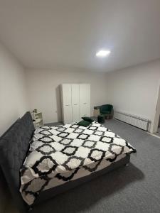Un dormitorio con una cama con un edredón blanco y negro. en Renoviran i novo namješten Apartman, en Velika Kladuša