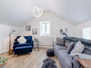 un soggiorno con divano e sedia blu di Puddle Duck Cottage a Kendal