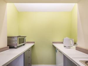 a kitchen with a microwave and a toaster oven at Owl Cottage in Howell +13 photos