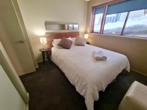 Un dormitorio con una gran cama blanca con ventana. en Absollut 09, en Monte Hotham