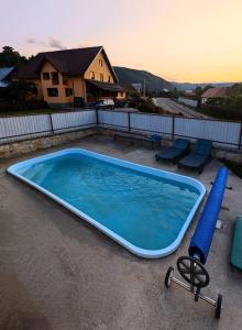 a large swimming pool with a blue tube and two chairs at Pensiunea Teona in Târgu Ocna