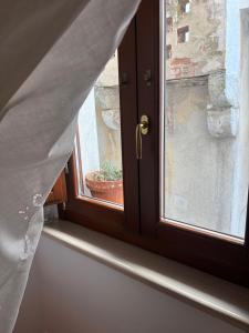 a window with a potted plant on a window sill at La Casetta in Ischitella