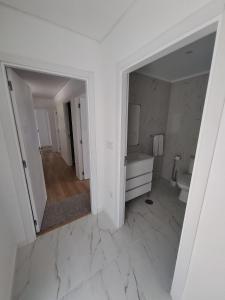 ein weißes Badezimmer mit Waschbecken und Toilette in der Unterkunft Casa Sambinho II Bela Vista in Rio Caldo + 25 Fotos