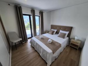 ein Schlafzimmer mit einem Bett und einem großen Fenster in der Unterkunft Casa Sambinho II Bela Vista in Rio Caldo