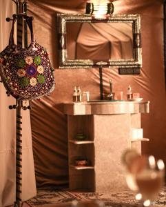 a bathroom with a sink and a mirror at Aurum Dunes Luxury Camp in Merzouga +79 photos