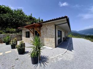 ein Gebäude mit Topfpflanzen davor in der Unterkunft Casa Sambinho II Bela Vista in Rio Caldo