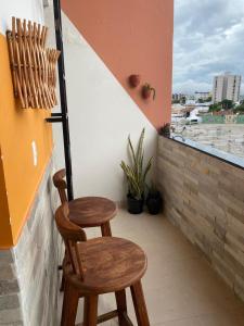een paar houten stoelen op een balkon bij Loft Lampião in Campina Grande
