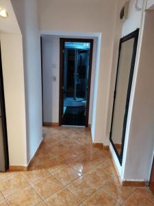 a hallway with a mirror and a door with a tile floor at House Teo in Văleni +2 photos