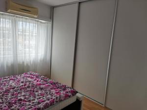 a bedroom with a bed with pink sheets and a window at House Teo in Văleni