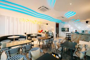 a restaurant with tables and chairs in a room at Madusea Grand Villa มาดูซี แกรนด์ วิลล่า in Ko Larn
