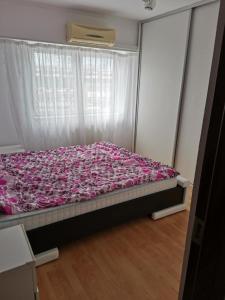 a bedroom with a bed with pink sheets and a window at House Teo in Văleni