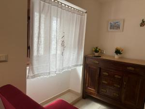 a room with a curtain and a dresser and a window at La Casetta in Ischitella