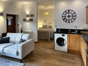 een woonkamer met een bank en een wasmachine bij Oak in Falmouth