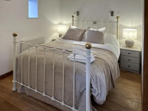 een slaapkamer met een wit bed met een witte sprei bij Oak in Falmouth