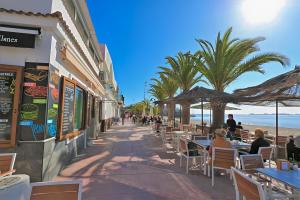 people sitting at tables on a sidewalk near the beach at Villamar Corner Retreat near beach, nature & shops in Los Albaladejos