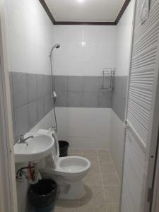 a bathroom with a toilet and a sink at Sales-Marzan Pension House Rental in Aringay