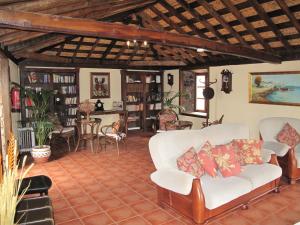 Casa Rural Vera De La Hoya في سان ميغيل ذي أبونا: غرفة معيشة مع الأرائك البيضاء وأرفف الكتب