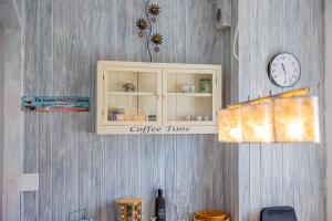 a cupboard with a coffee timer and a clock on a wall at Apartmani Simona Tribunj in Tribunj +13 photos