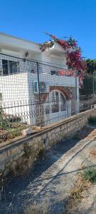 a fence in front of a building with flowers at Apartman Asja in Utjeha