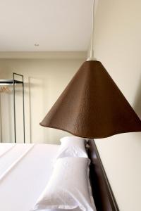a lamp hanging over a bed with a white pillow at Aquarelle Boutique Hotel in Ksamil +21 photos