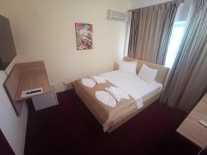 a hotel room with a bed with white sheets and pillows at For Fun resort naturist libertin - adults only in Costinesti +53 photos