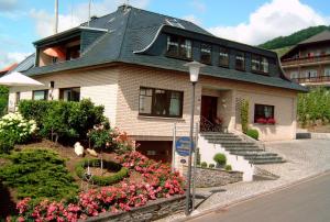 a large house with flowers in front of it at Gästehaus Heidi in Kröv