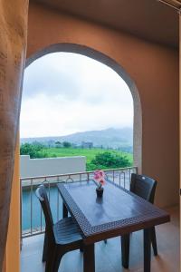 a table and chairs on a balcony with a view at Breeze Resort Panhala , Swimming Pool, Just 5 Minutes From Panhala! in Panhāla