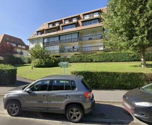 un'auto argentata parcheggiata davanti a un edificio di Charmant T3, Parking & Wi-fi, Cuisine équipée a Villers-sur-Mer