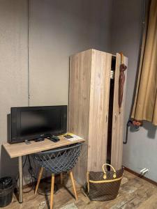 a wooden cabinet with a tv and a desk with a television at Mezzanine Hotel in Odesa