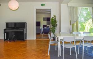 a dining room with a table and chairs and a television at Beautiful Home In Flyinge in Flyinge