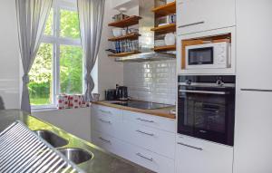 a kitchen with white cabinets and a microwave at Beautiful Home In Flyinge in Flyinge