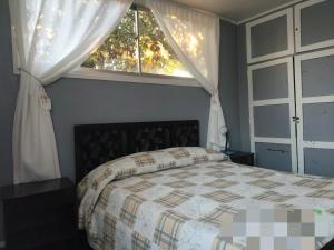 una camera da letto con un letto e una finestra di Casa central cerca de todo a Los Ángeles
