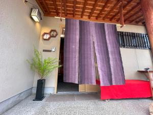 una camera con finestra con tenda viola di 日本庭園と文化体験の宿深見屋 一棟貸し送迎付き6名様まで追加宿泊料金なし a Hakusan