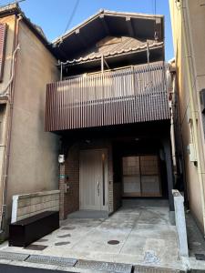 大阪市にある3LDK Entire house for rent 3 bedrooms, 2 toilets, and parking lot! Close to the station, USJ, and Expo!のドアとバルコニー付きの建物