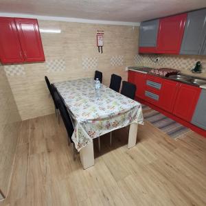 a kitchen with a table with chairs and red cabinets at Cantinho da Familia in Avis