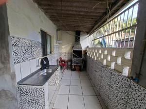 a kitchen with a sink and a counter in a room at Casa 2 minutos a pé da Praia de INDAIÁ in Bertioga