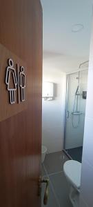 bagno con doccia e porta con servizi igienici di Faro Station Eleven Guest House a Faro