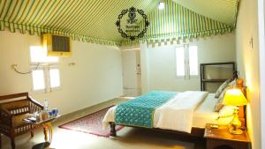 A bed or beds in a room at Rajputana Desert Camp